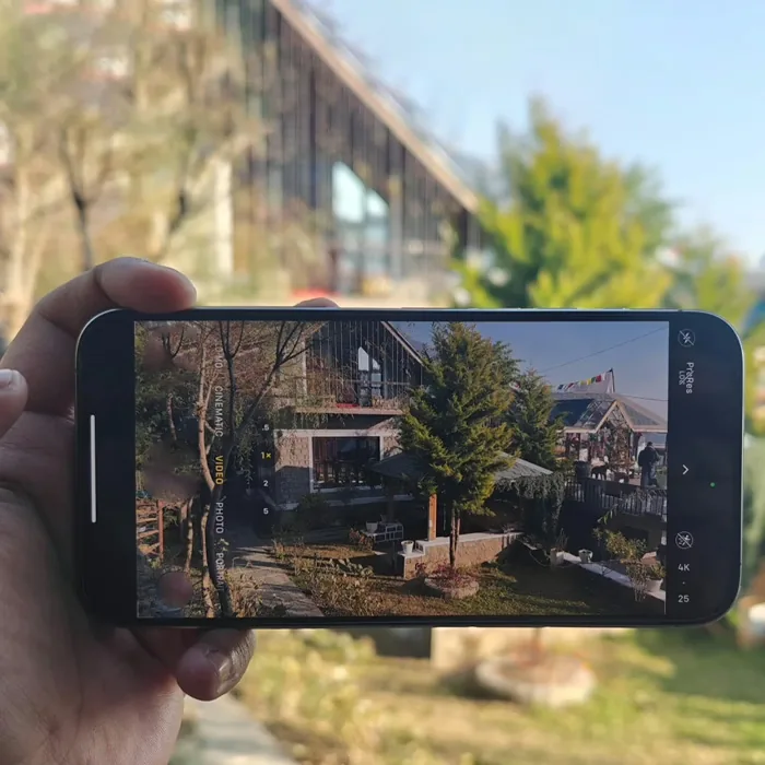 Hand holding a smartphone that shows the live PebblePeek video of a living room